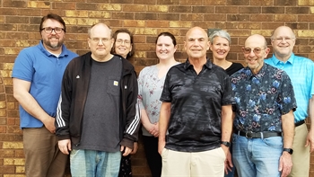 Photo of eight WIU librarians standing against a brick wall.